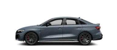 Audi RS3 v kovinski, kemora sivi barvi, stranski pogled, prikazuje kompaktno športno limuzino z izrazitimi oblikovnimi elementi, velikimi platišči in rdečimi zavorami.